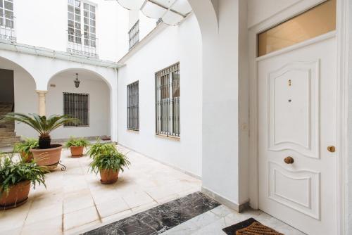a hallway with potted plants and a white door at apartamento cerca de la catedral in Seville