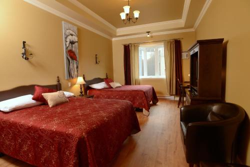 Cette chambre comprend deux lits et une télévision. dans l'établissement Motel du Littoral, à Rimouski