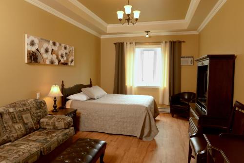 una camera d'albergo con letto e divano di Motel du Littoral a Rimouski