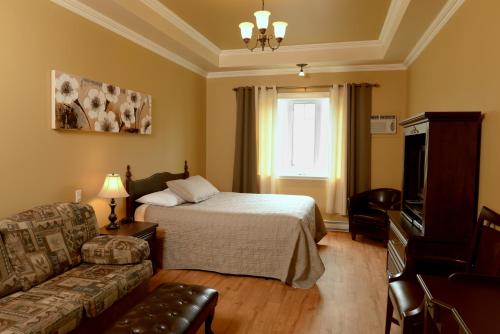 a hotel room with a bed and a couch at Motel du Littoral in Rimouski