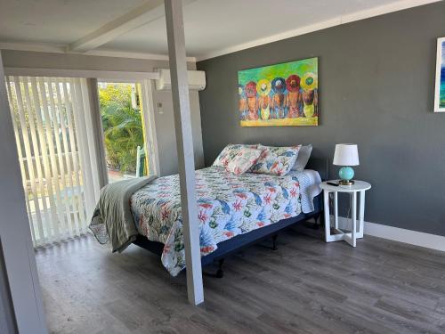 a bedroom with a bed and a painting on the wall at Angler's Inn in Matlacha