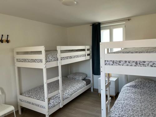 two white bunk beds in a room with a window at Naturotel in Fort-Mahon-Plage