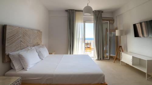a bedroom with a large white bed and a window at Sea Bliss Adults Only in Parga
