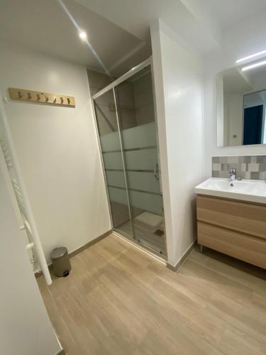 W łazience znajduje się szklana kabina prysznicowa i umywalka. w obiekcie Naturotel w mieście Fort-Mahon-Plage