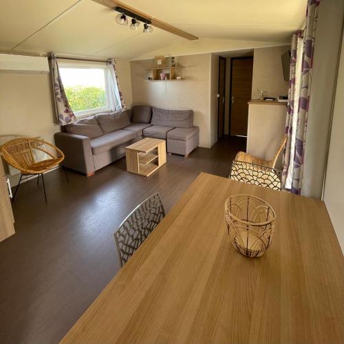 a living room with a table and a couch at Parc Résidentiel La Listra - Bungalow in Belgodère