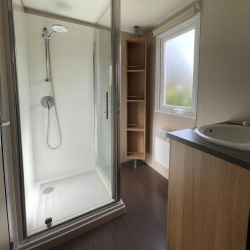 W łazience znajduje się prysznic i umywalka. w obiekcie Parc Résidentiel La Listra - Bungalow w mieście Belgodère