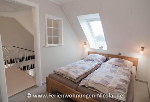 uma cama num quarto com uma janela em Panorama Schönberger-Strand Appartement 29 em Stakendorfer Strand