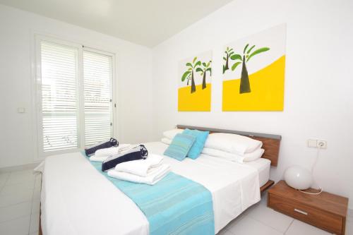 a white bedroom with two beds and a window at Viva Sitges - Mayo Terrace in Sitges