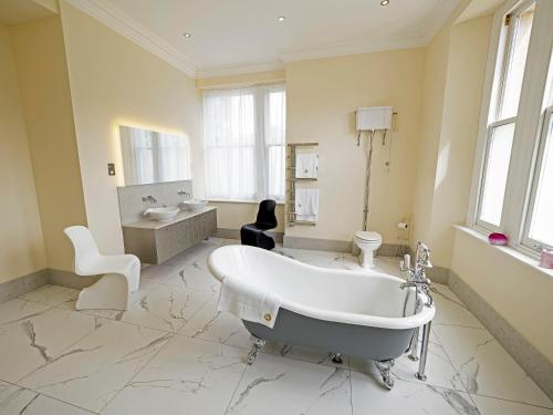 a large bathroom with a tub and a sink at 6 Bedroom Luxury Manor House in Newbury