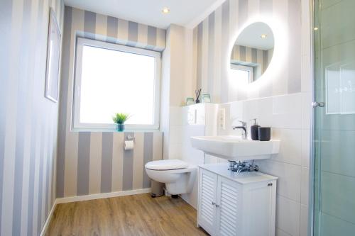 La salle de bains est pourvue d'un lavabo, de toilettes et d'une fenêtre. dans l'établissement Homefy Come-Together Apartment - Balkon - Aufzug - Free Parking - Smart TVs, à Essen