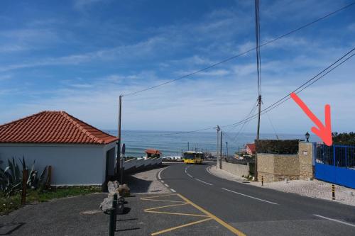 a road with a yellow bus driving down a street at Mega Ocean Magoito - Sintra in Sintra