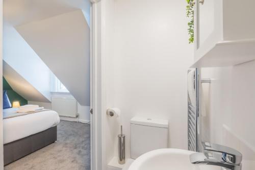 a bathroom with a bed and a sink in a room at Stylish Studio 7 with Kitchenette by CB Stays no minimum stays in Cambridge