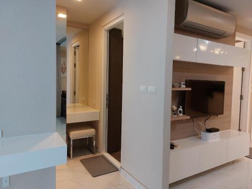 Condominium Sukhumvit Soi 5 - BTS Nana- Room Size 47m2 في Makkasan: غرفة معيشة مع تلفزيون وجدار أبيض