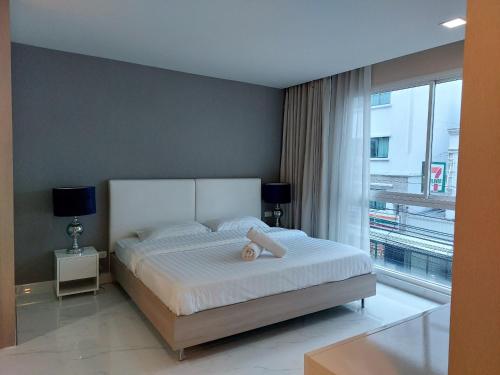 Condominium Sukhumvit Soi 5 - BTS Nana- Room Size 47m2 في Makkasan: غرفة نوم بسرير ونافذة كبيرة