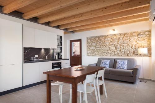 a kitchen and living room with a table and a couch at Casa Rosa in Brenzone sul Garda