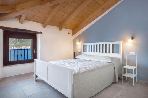 a bedroom with a white bed and a window at Casa Rosa Rosadalake in Brenzone sul Garda