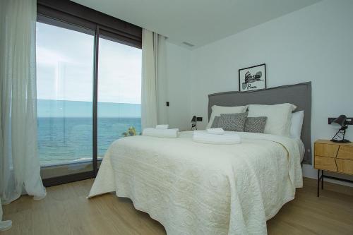 a bedroom with a large bed and a large window at 138 Miramar Luxury Relax - Alicante Holiday in La Mata