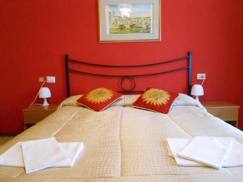 a bedroom with a large bed with red walls at Hotel Aline in Florence