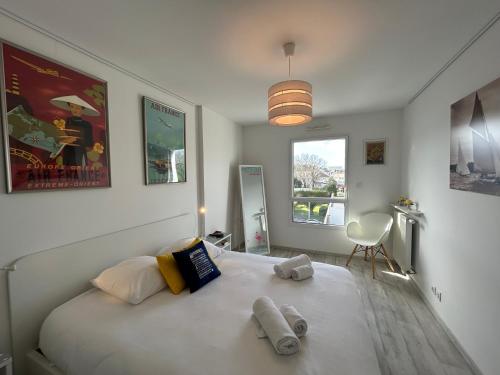 1 dormitorio con 1 cama blanca grande y toallas. en Les Terrasses Marines - Vue imprenable sur le port de plaisance en Vannes