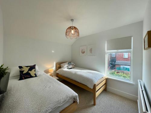 a bedroom with two beds and a window at TAFFS MEAD HOUSE Central City Location, nr Stadium, Family Friendly in Cardiff