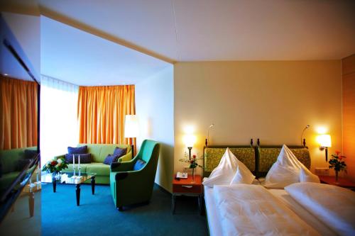 a hotel room with a bed and a couch at Parkhotel Flora am Schluchsee in Schluchsee