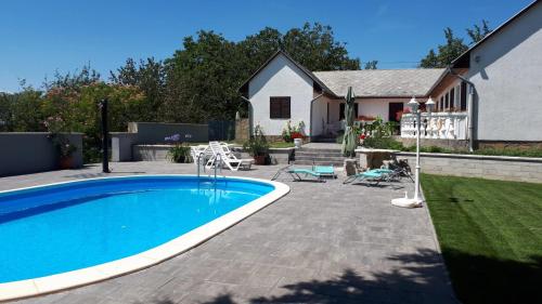 a backyard with a swimming pool and a house at Főnix Apartmanház in Vonyarcvashegy