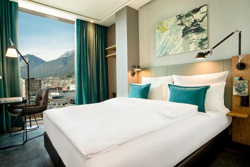 pokój hotelowy z dużym łóżkiem i oknem w obiekcie Motel One Innsbruck w mieście Innsbruck