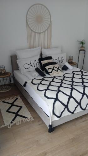 łóżko z czarno-białymi kocami i poduszkami w obiekcie Apartament w Pieninach w Krościenku