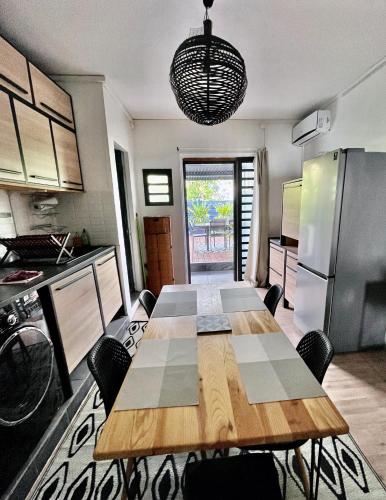 a kitchen with a wooden table and a refrigerator at Lelaleu in Saint-Leu