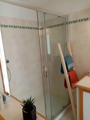 une douche avec une porte vitrée dans une salle de bain dans l'établissement Les Orangers de Santa Lucia, vue mer et port, St Raphaël, à Saint-Raphaël