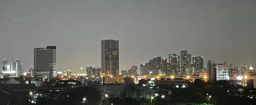 a city skyline at night with lit up buildings at ORION Hotel & Residence Bangna in Bangkok