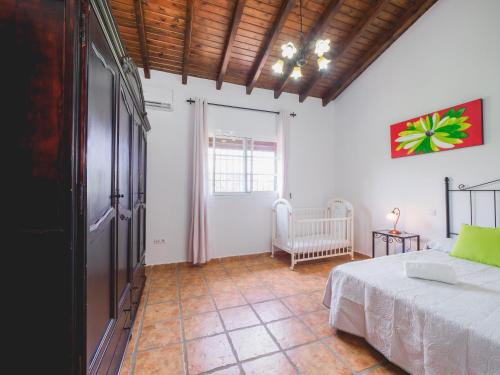 Cubo's Casa El Recreo de La Abuela في لاورين إل غراندي: غرفة نوم بسرير وكرسي في غرفة