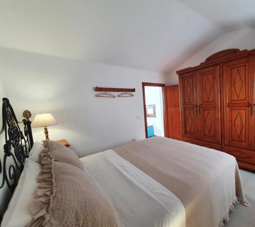 1 dormitorio con 1 cama grande y vestidor de madera en Lanzarote Casa azul en La Santa