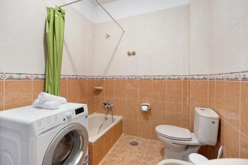 Vivienda Vacacional Timarasan في Lodero: حمام مع غسالة ومرحاض