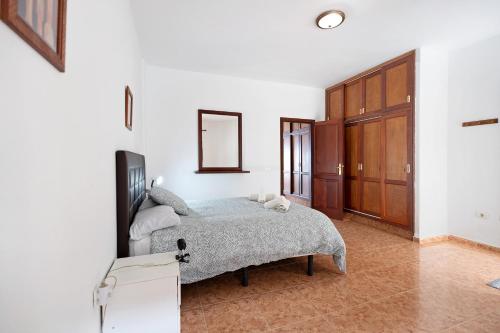 Vivienda Vacacional Timarasan في Lodero: غرفة نوم مع سرير وخزانة خشبية