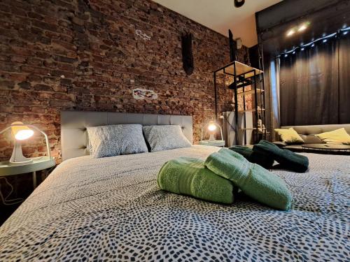 1 dormitorio con 1 cama grande y pared de ladrillo en Le 23 - La Roche-en-Ardenne, en La-Roche-en-Ardenne