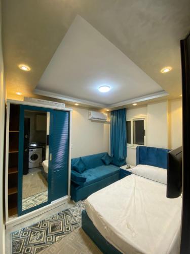 Zimmer mit einem Bett und einem blauen Sofa in der Unterkunft استديو in Madinat as-Sadis min Uktubar