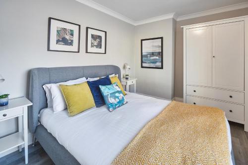 a bedroom with a large bed with yellow and blue pillows at Host & Stay - No.8 in Witton Gilbert