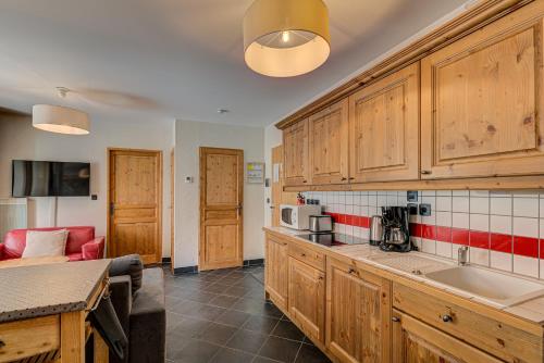 une cuisine avec des armoires en bois et un comptoir dans l'établissement APARTMENT LE PARADIS 2 - ALPES TRAVEL - CENTRAL CHAMONIX (sleeps4-5), à Chamonix-Mont-Blanc