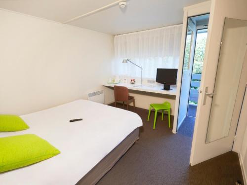 1 dormitorio con 1 cama y escritorio con ordenador en Campanile Nantes ~ Rezé Aéroport, en Rezé