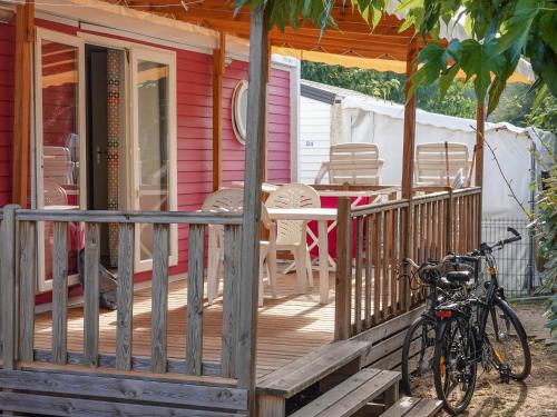 a bike parked on the porch of a house at Camping Pleine Mer in Vias