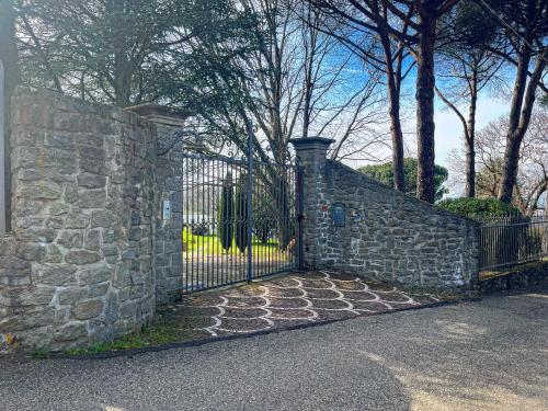 a stone fence with a gate in front of a house at Labella Villa in Viterbo