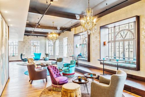 a lobby with chairs and tables and windows at Motel One Edinburgh-Princes in Edinburgh