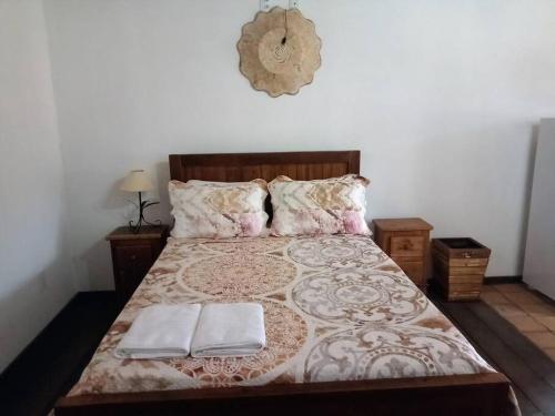 a bedroom with a bed with two towels on it at Loft Aconchego in Tiradentes