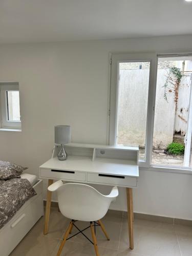 - un bureau blanc avec une chaise à côté d'un lit dans l'établissement Chambre 14m2, à Massy