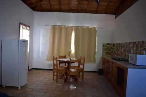 a kitchen with a table and chairs and a window at Loft Aconchego in Tiradentes
