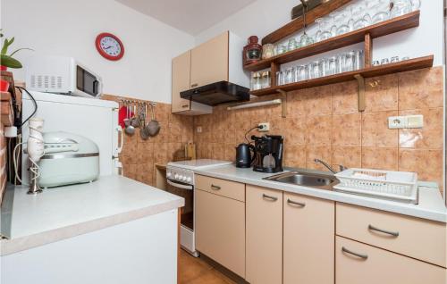 kuchnia z białą lodówką i zlewem w obiekcie Pet Friendly Apartment In Supetarska Draga With Wifi w mieście Supetarska Draga