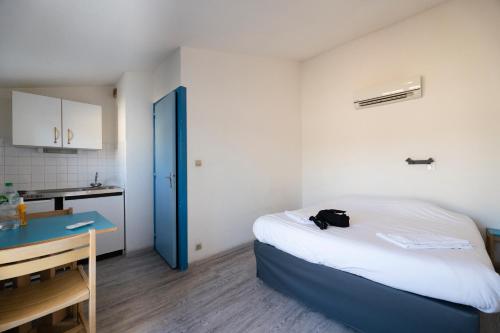 a small room with a bed and a kitchen at Le Pescadou in Martigues
