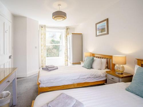 a bedroom with two beds and a window at Gwbert Holiday Cottages, Green Meadow in Cardigan
