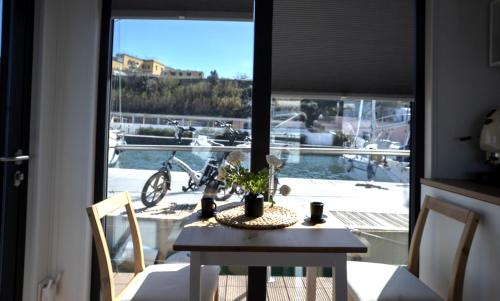 a dining room table with a view of a boat at ALMALO Floating House - Casa Galleggiante in Procida